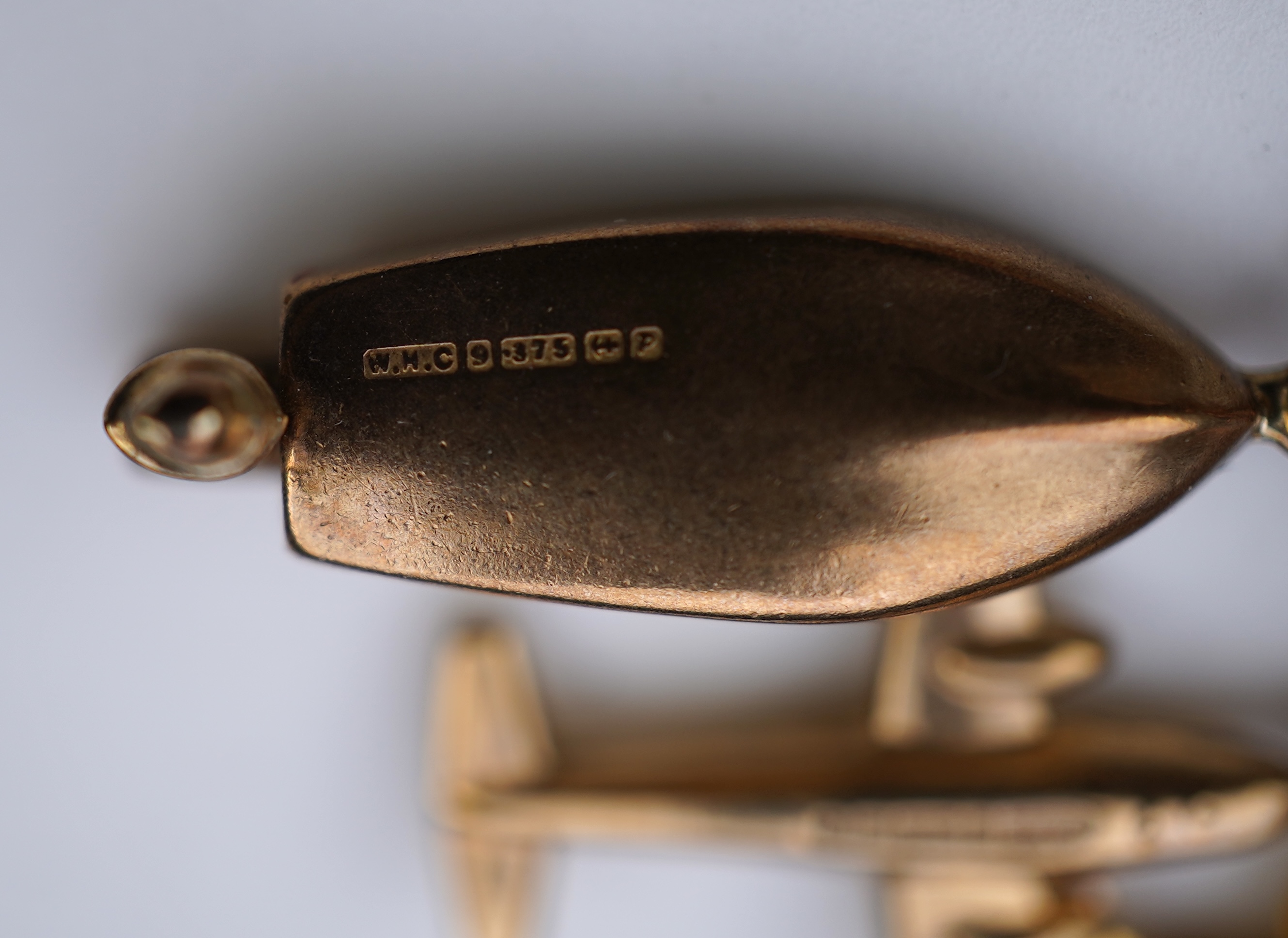 A gold charm bracelet, mid 20th century